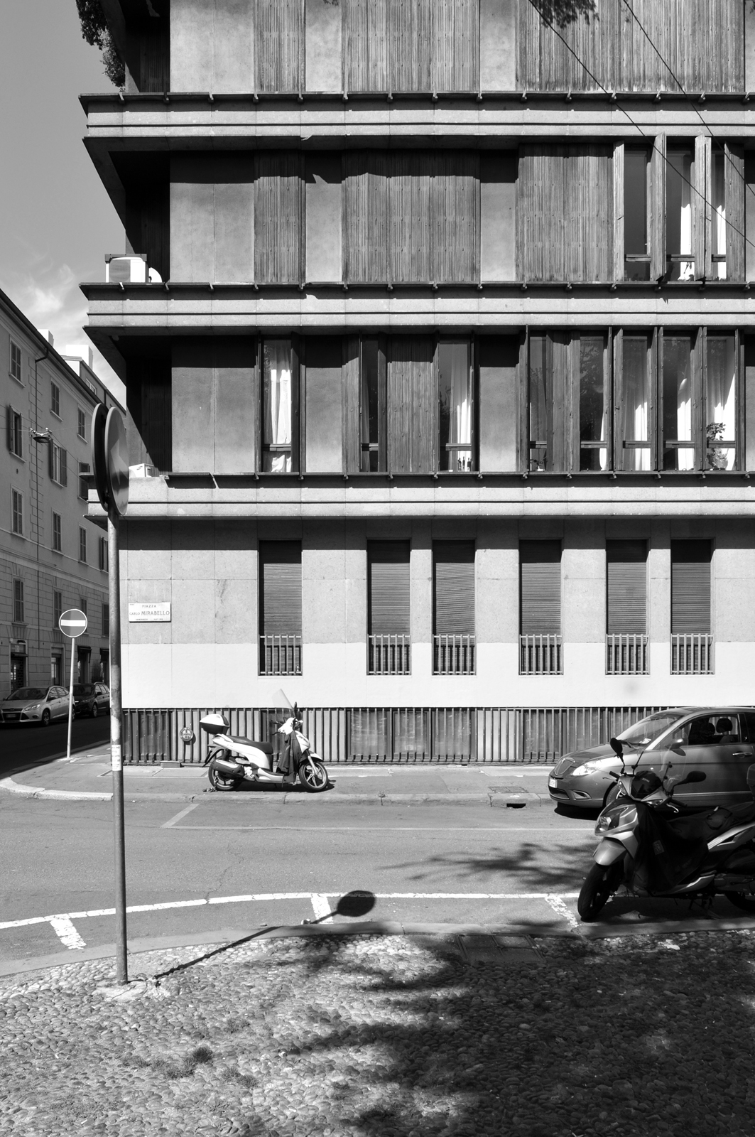 Fotopiano di dettaglio della facciata su piazza Mirabello con in evidenza l'alternanza tra i pannelli prefabbricati e i serramenti a tutt'altezza con pregevoli scuri in legno