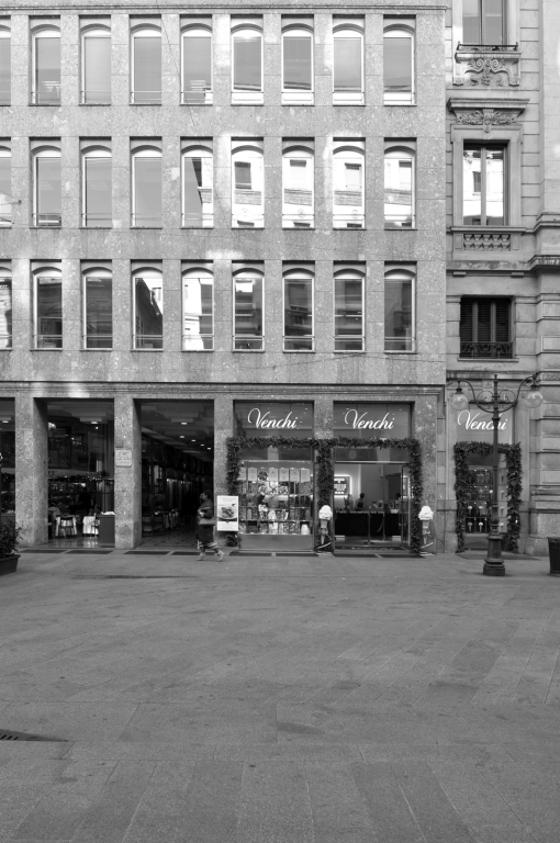 Fotopiano di dettaglio della facciata su via dei Mercanti con la sequenza regolare delle aperture e gli archi ribassati negli sfondati delle finestre