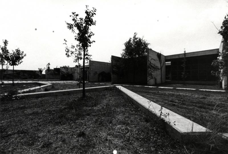 Il fronte principale del nuovo cimitero: in primo piano il giardino verso il cimitero storico con le sedute inclinate e le nuove alberature