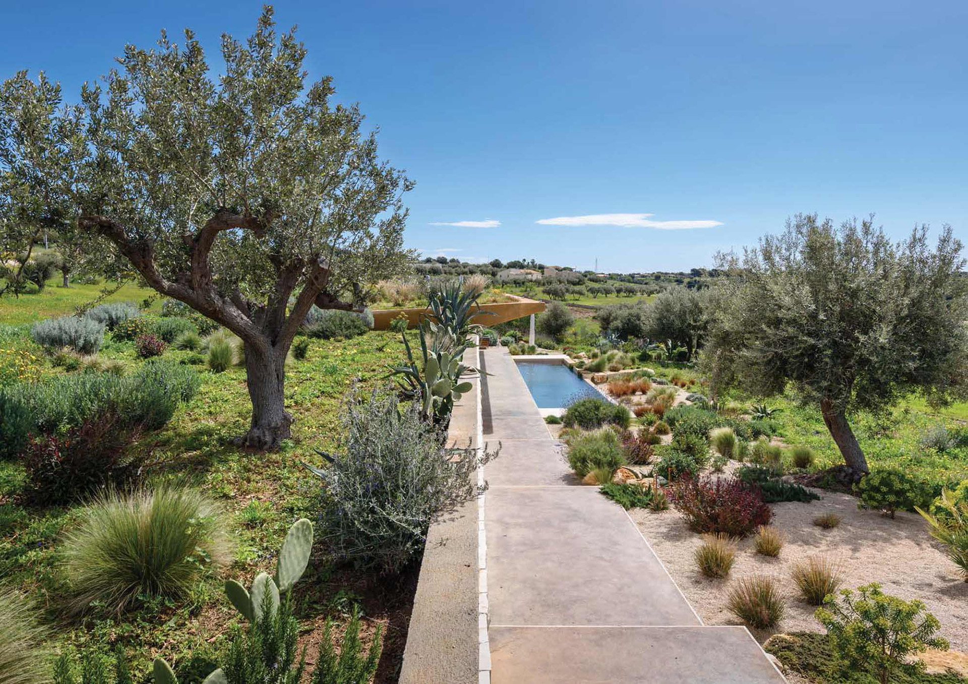 Il percorso lungo il muro di contenimento che diventa il prospetto dell'edificio 