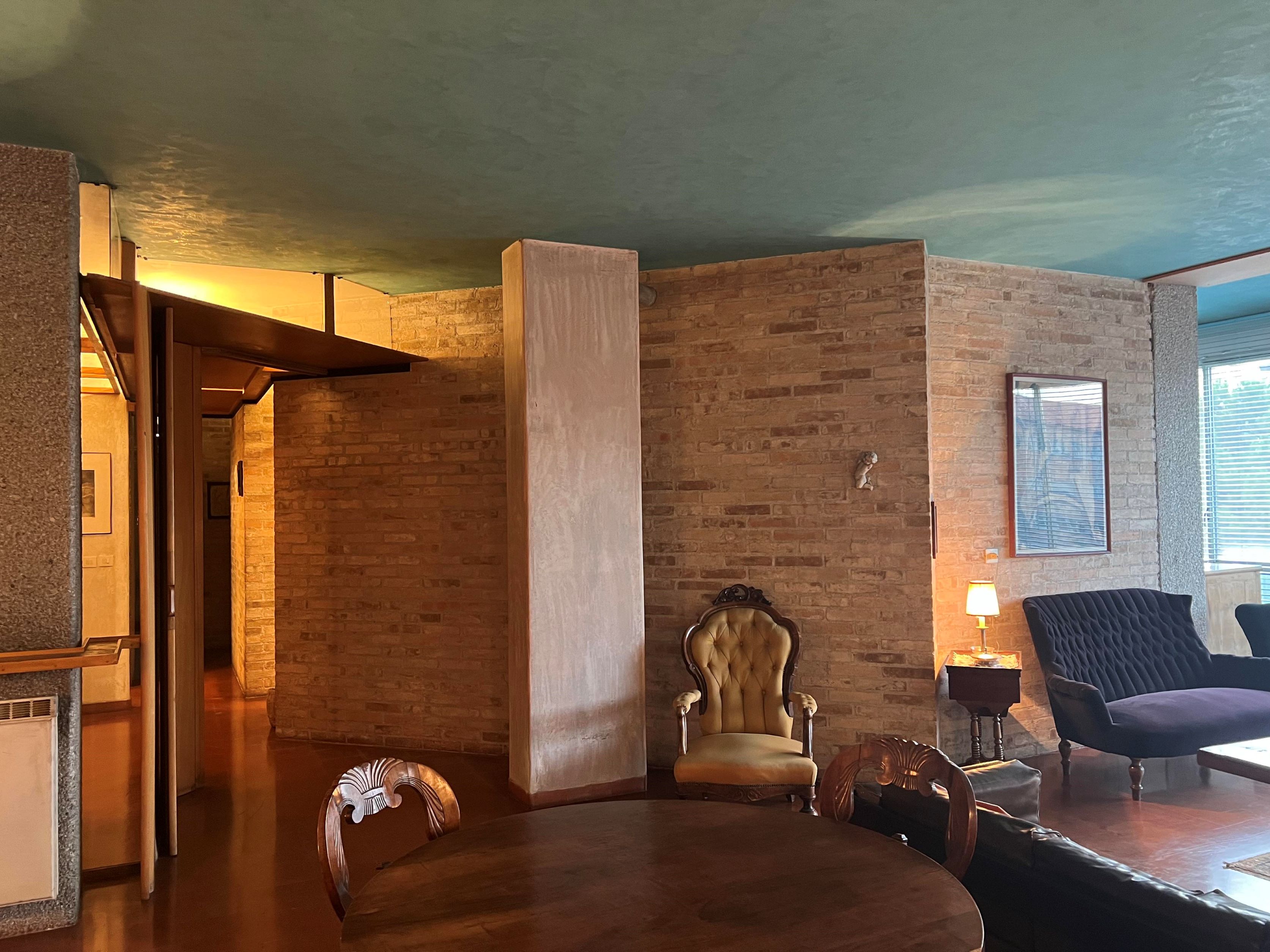 Veduta del soggiorno con al centro il volume della canna fumaria 