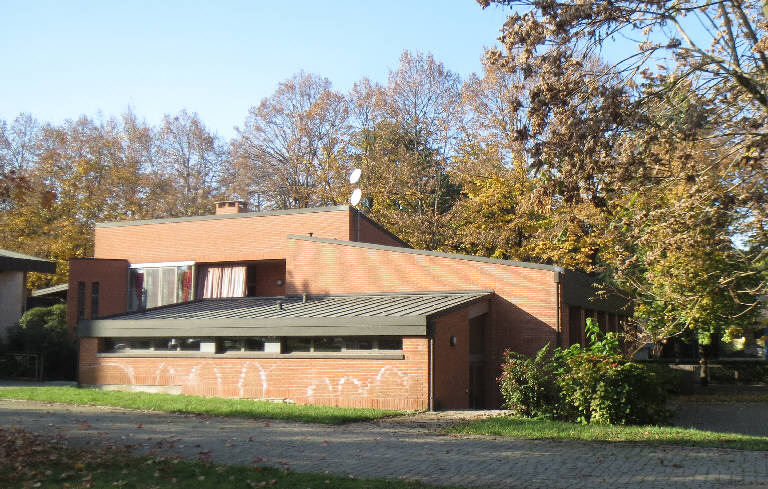 Primary subject is CAPPELLA DEL SACRO CUORE in Pavia. The surrounding environment shows the urban or architectural context of the building, with the work presented as the main focus.